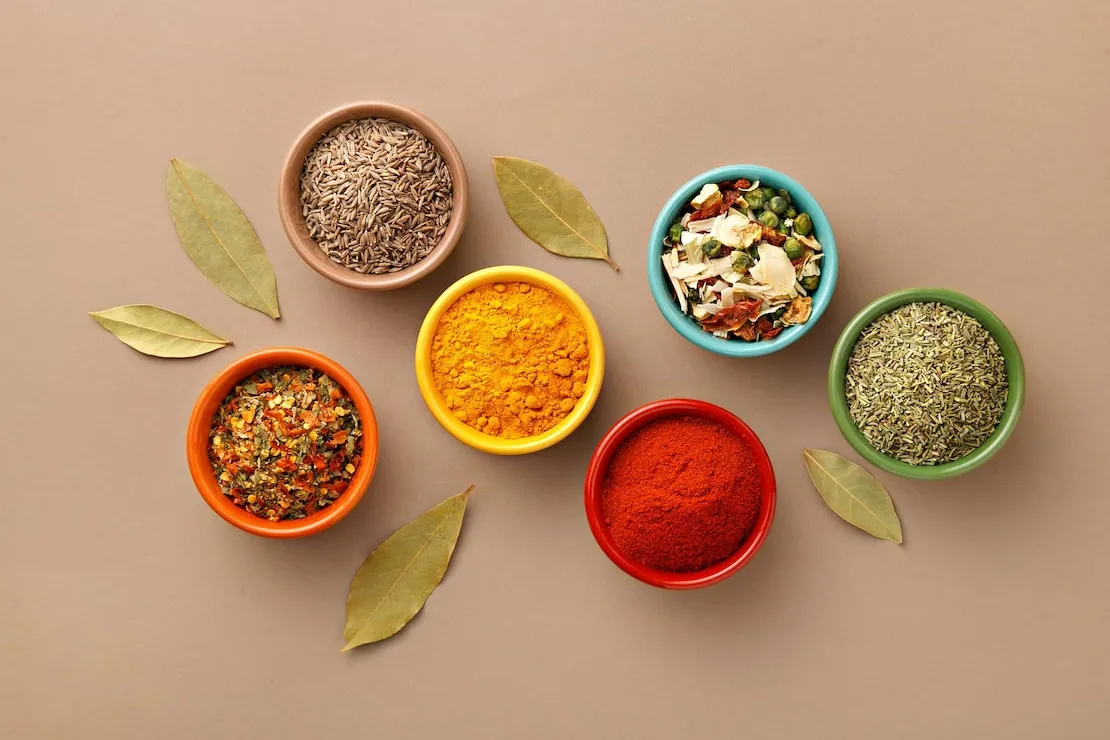 مجموعه‌ای از ادویه‌های خالص و رنگارنگ ادویه قرمز روی قاشق‌های چوبی